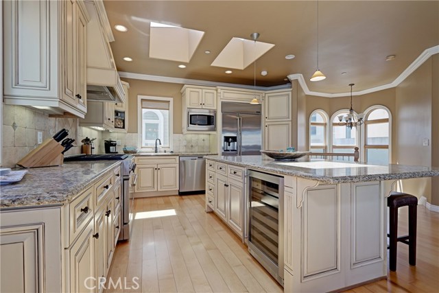 Sun-drenched Chef's kitchen with skylights, custom cabinetry, Wine cooler, and entertaining bar.