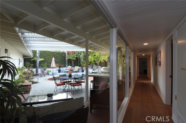 View of the pool area and patio as seen from the hallway with wall of windows.  This house is so open and airy, and offers amazing indoor/outdoor living and entertaining!