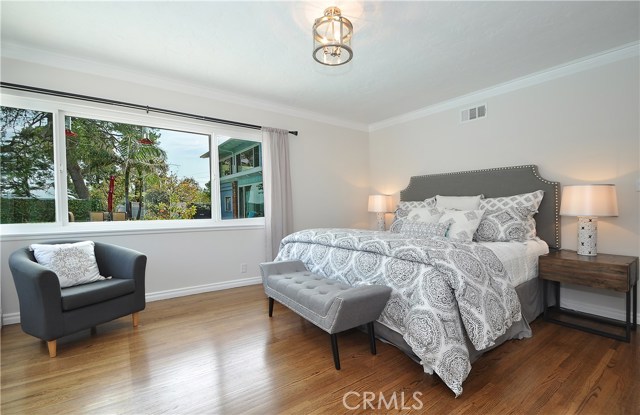 Master bedroom with hardwood floors and crown molding