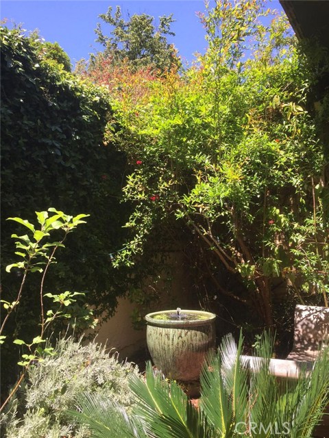 garden area close up with balinese lounge chair and fountain garden area close up with balinese lounge chair and fountain