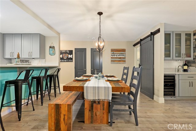 GREAT Dining Space sandwiched by the open kitchen and living space, with Barn Door to Master Suite in the background and Lifeguard Tower accent wall on the bar to the kitchen!