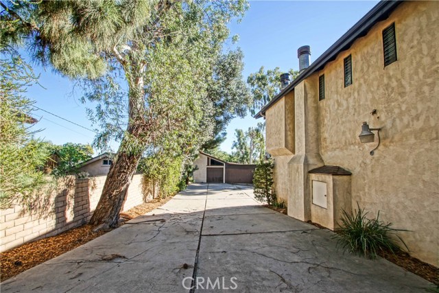 Very long driveway that slops down around the back of the house. Also pictured is the large garage.