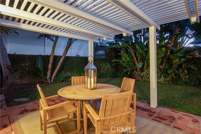 The lush and tranquil backyard with patio and pergola.