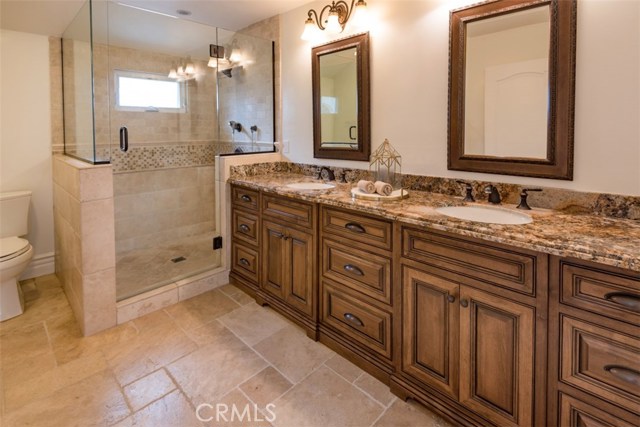 Master Bathroom with dual sinks, granite, custom cabinets and travertine.