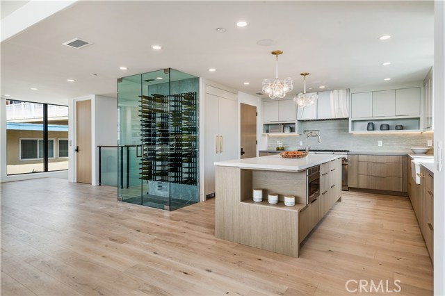 The gourmet kitchen has unique and modern finishes including a floor to ceiling glass wine cellar