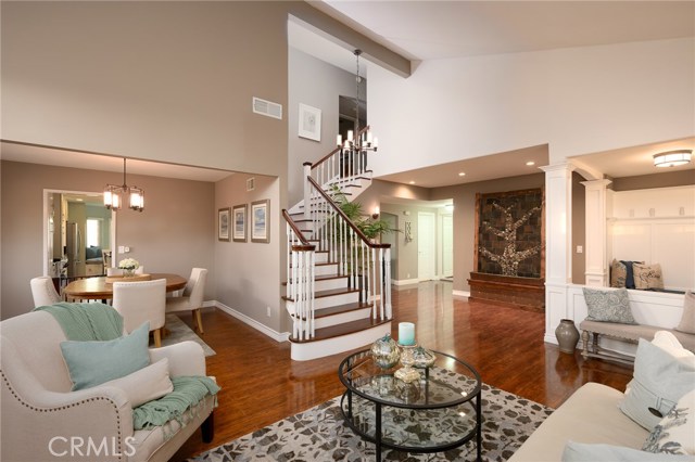 View of living room high ceiling, staircase, and dining area