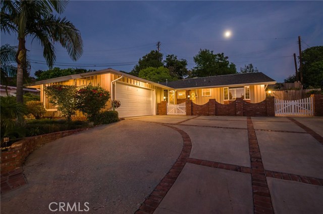 Night view with gated front patio leading to front door