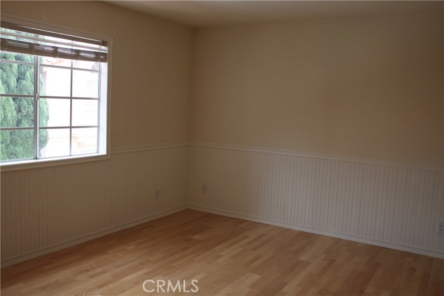 Third bedroom with decorative wainscoting and a walk-in closed