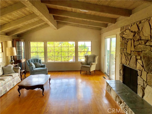 Living Room with Original Hardwood Floors and Two sided Stone Fireplace and Views out toward the City