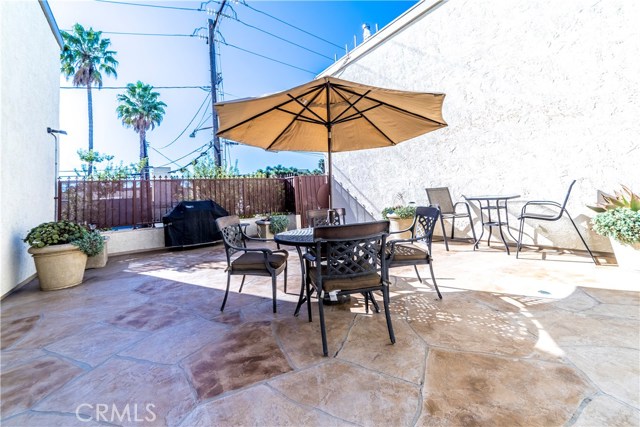 Courtyard features BBQ and dining/seating area. Gate at far end opens out to a staircase that leads to park and beach access at the end of the block.