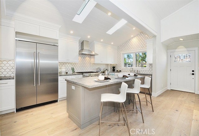 Beautifully remodeled kitchen with Caesarstone counters, designer's marble back splash and built-in refrigerator