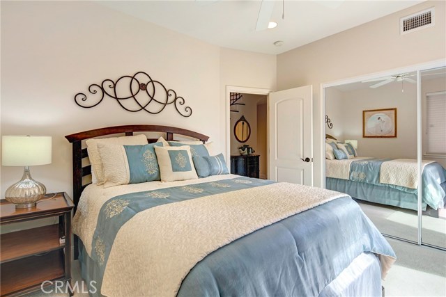 Downstairs bedroom #1 with large closet, ceiling fan, recessed lights, and access to backyard.