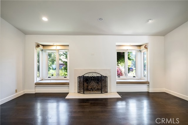 Living Room features window seats and fireplace and looks onto lush landscaping