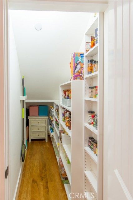 custom built in pantry has tons of storage space and even more as it wraps under the stairs