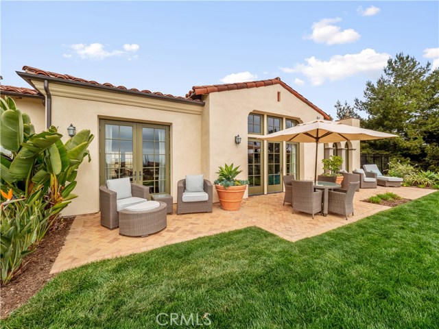 Full view of outdoor patio with doors to the kitchen, great room and master bedroom. In ground Jacuzzi-type spa on far right.