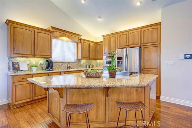 Huge island in a cook's kitchen with granite counters, all stainless appliances, breakfast bar, and tons of cabinet space.
