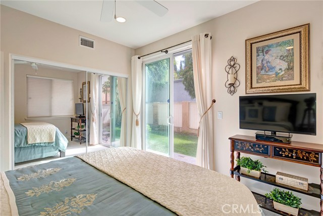 Downstairs bedroom #1 with large closet, ceiling fan, recessed lights, and access to backyard.