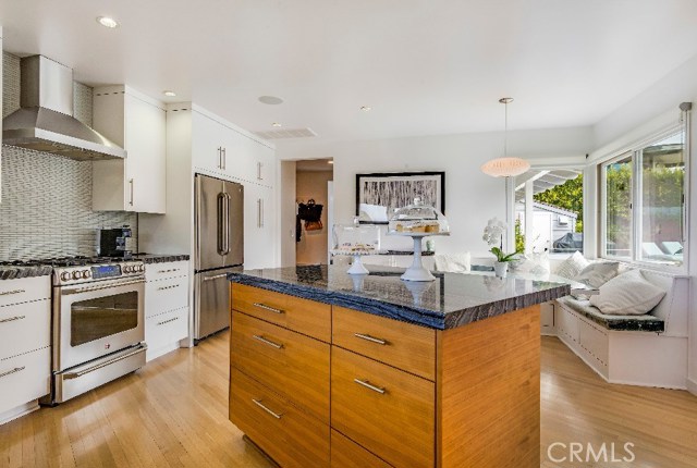 The combination of custom white cabinetry and a teak-finished island provide the perfect contrast and consistently delivering the heritage of Mid-Century style with the flair of today.