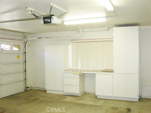 INSIDE THE LARGE FULLY DRYWALL FINISHED GARAGE. THERE'S STORAGE CUPBOARDS AND WORKBENCH OPTIONS ON EVERY WALL.NEW GARAGE DOOR OPENER.