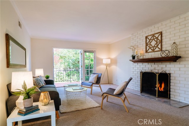 The living room with warm fireplace opens to the veranda and backyard.