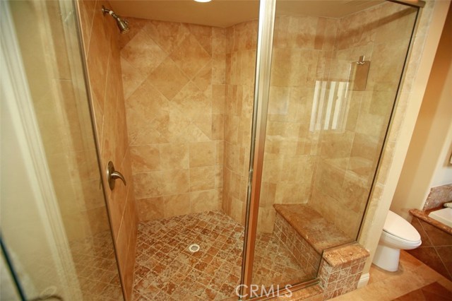 Opulent Travertine master shower with built-in bench!