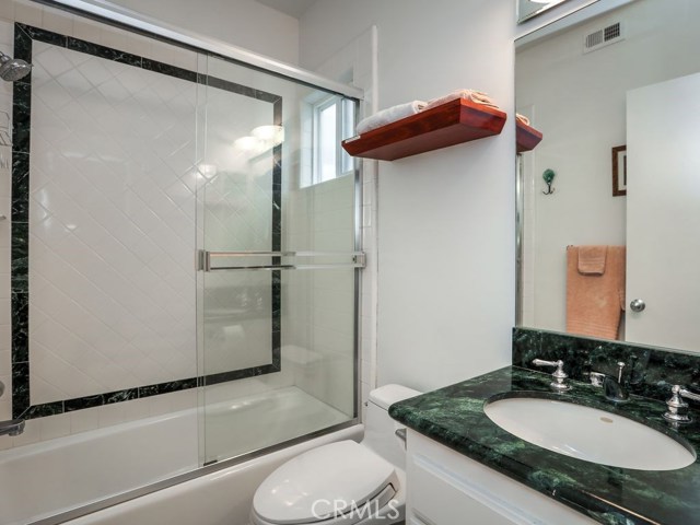 The En-suite bathroom for bedroom 2 features a tub/shower combo and mirrored vanity.