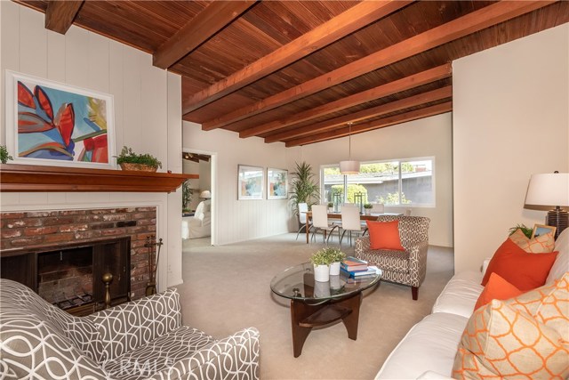 Living area with fireplace. Beamed ceilings.  If you prefer, add drywall to area between beams, paint and will change decor.  Inexpensive.