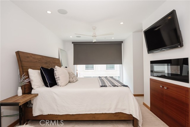 Primary suite with a faux fireplace and tons of natural light.