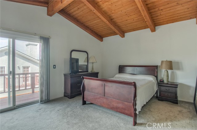 Large master bedroom with balcony overlooking backyard