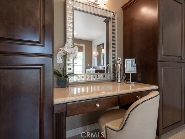 Seated vanity in the master bathroom with lighted makeup mirror and ample natural light.