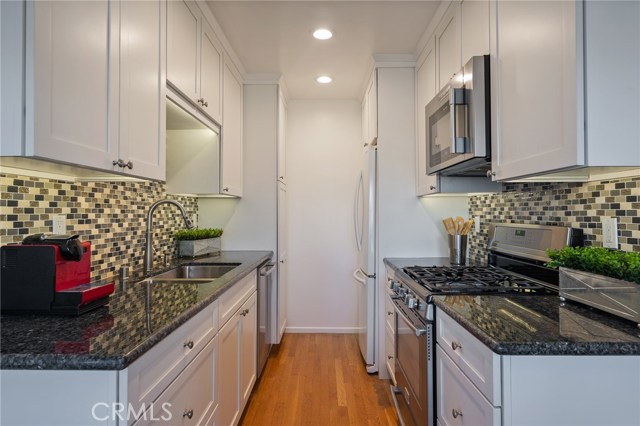 Remodeled kitchen of the back unit with granite countertops and tile backsplash.