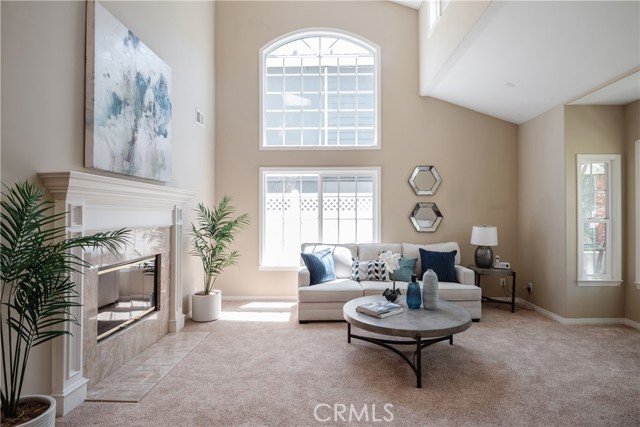 Light filled Living Room with vaulted ceiling, transom windows and double-sided fireplace