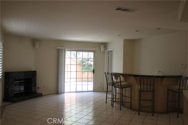 Den showing fireplace, bar and sliding doors leading to patio