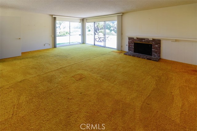 Living room with fireplace opens to backyard.