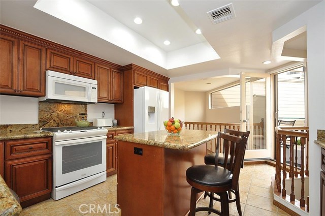 Kitchen with Center Island Opens to Interior Deck and Foyer Below