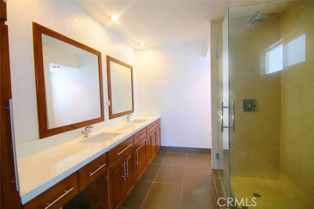 En suite master bath with jetted tub, double sinks, glass-enclosed shower, upgraded cabinets and stone counter tops.