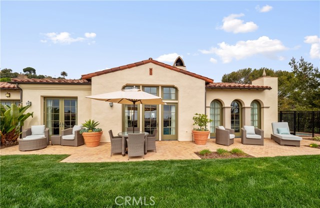 The outdoor patio can be accessed from the kitchen, great room and master bedroom. The iron gates on the right house the in-ground Jacuzzi type spa.