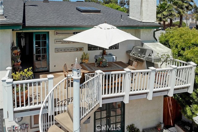 deck off kitchen with fireplace and stairwell down to backyard