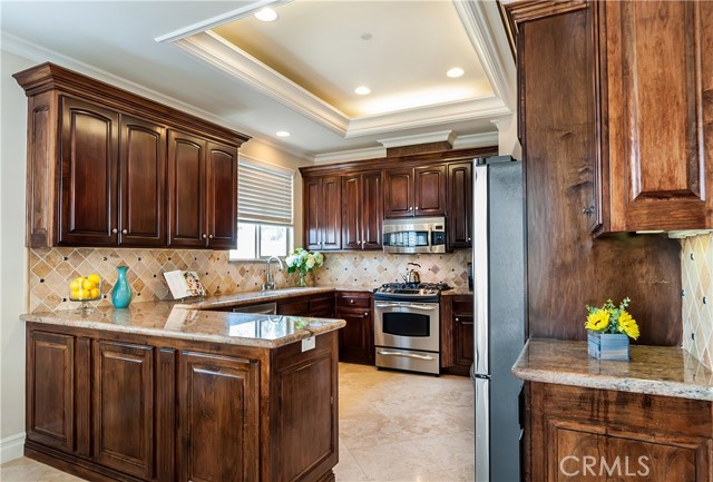 The kitchen features walnut stained cabinets and granite countertops.