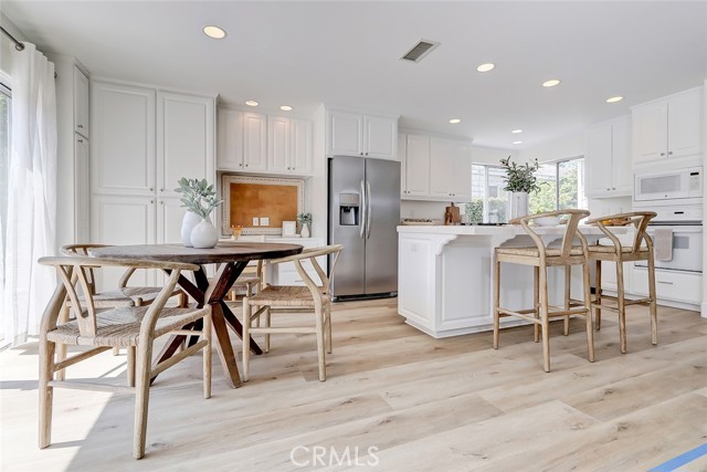 MAIN FLOOR BREAKFAST NOOK AREA AND ADJACENT ISLAND COOKTOP AND BREAKFAST BAR COUNTER