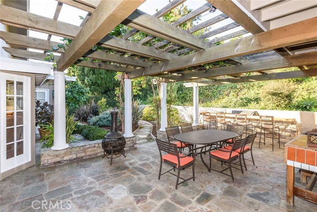 Gorgeous rear patio with slate flooring, wood pergola, and built in BBQ island.