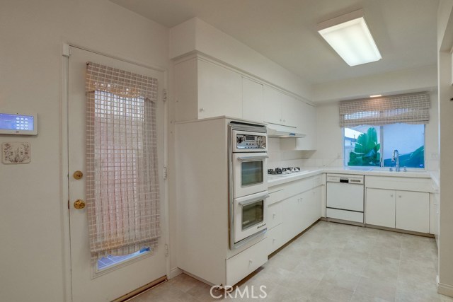 Kitchen with pedestrian door leading to side of house.