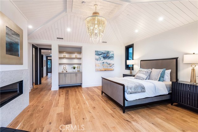 Vaulted ceiling with a custom wood treatment. Granite Face Fireplace with Custom Tapered Seams. Pre-wired for Surround Sound and Television. More custom wood cabinets with floating shelves with under-shelf lighting.