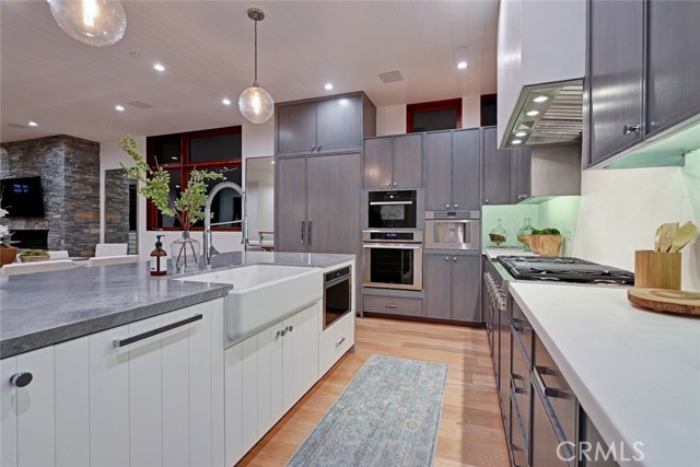 Solid, slab quartz countertop and backsplash along the perimeter (also surrounding the hood)