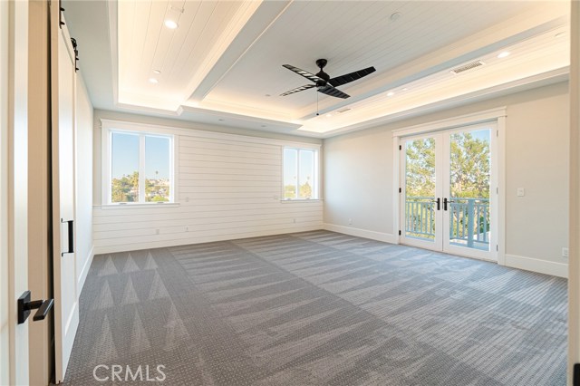 View of Master-suite from door. French doors that open to balcony, with a view of backyard.