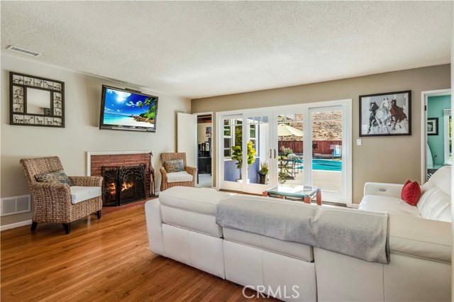 Living room with brick fireplace and view of large backyard and pool