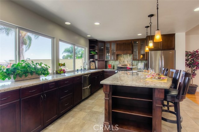 The oversized counter with decorative lights is the perfect spot for the children to do their homework while cooking dinner after a busy day.