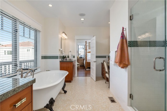 Private Owner Bath with three vanities, freestanding/club-footed soaking tub, glass-enclosed shower, privacy door to water closet and ocean views from windows!