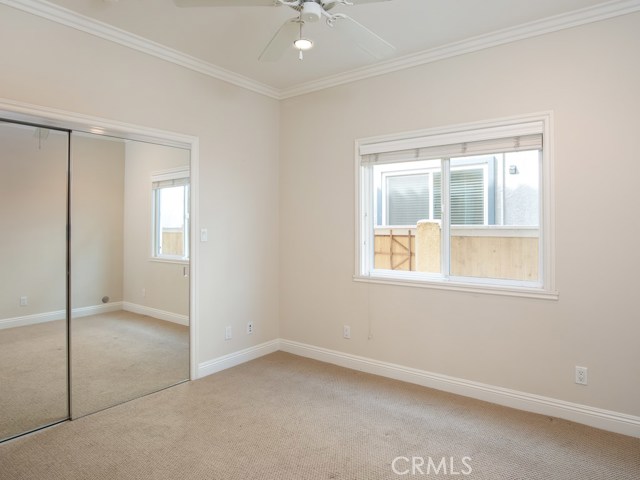 First floor 2nd bedroom, with warmth of crown molding, mirrors closets and ceiling fans and newer carpet