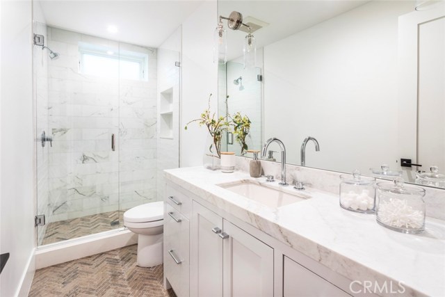 Basement bathroom completed in neolith quartz, herringbone textured limestone floor and Carrara marble shower